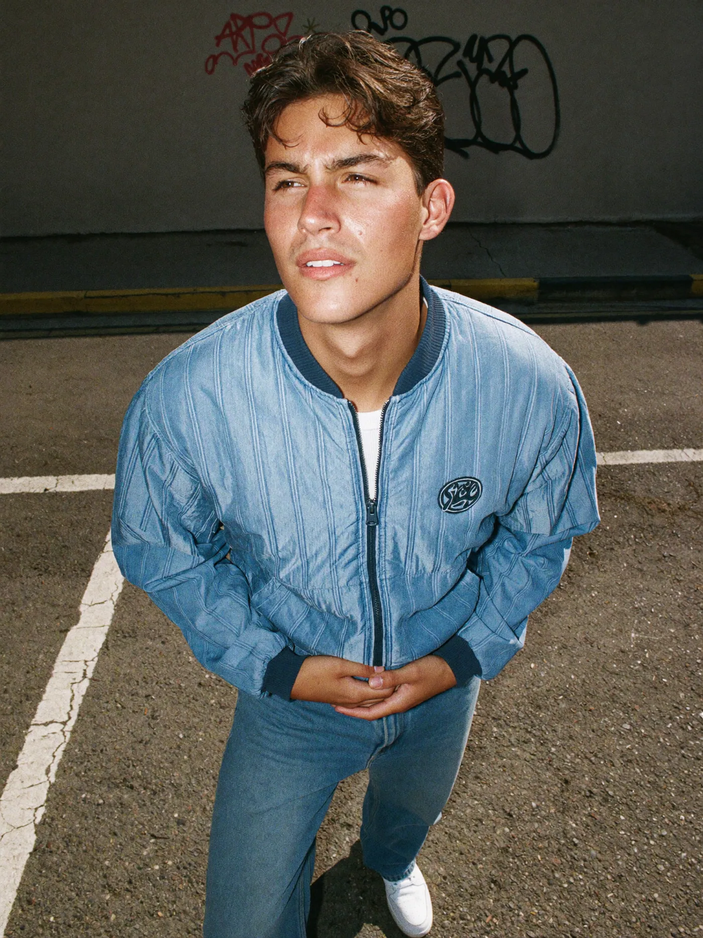 Wide-angle street portrait in a powder-blue jacket