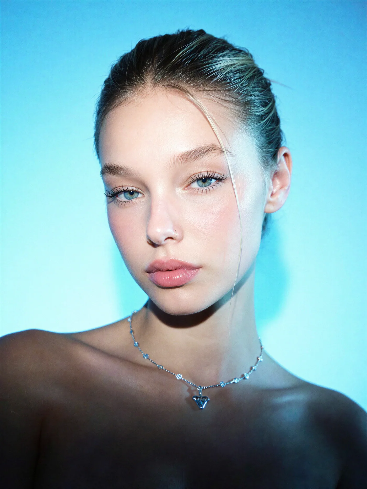 Clean cyan studio beauty portrait with hard directional light