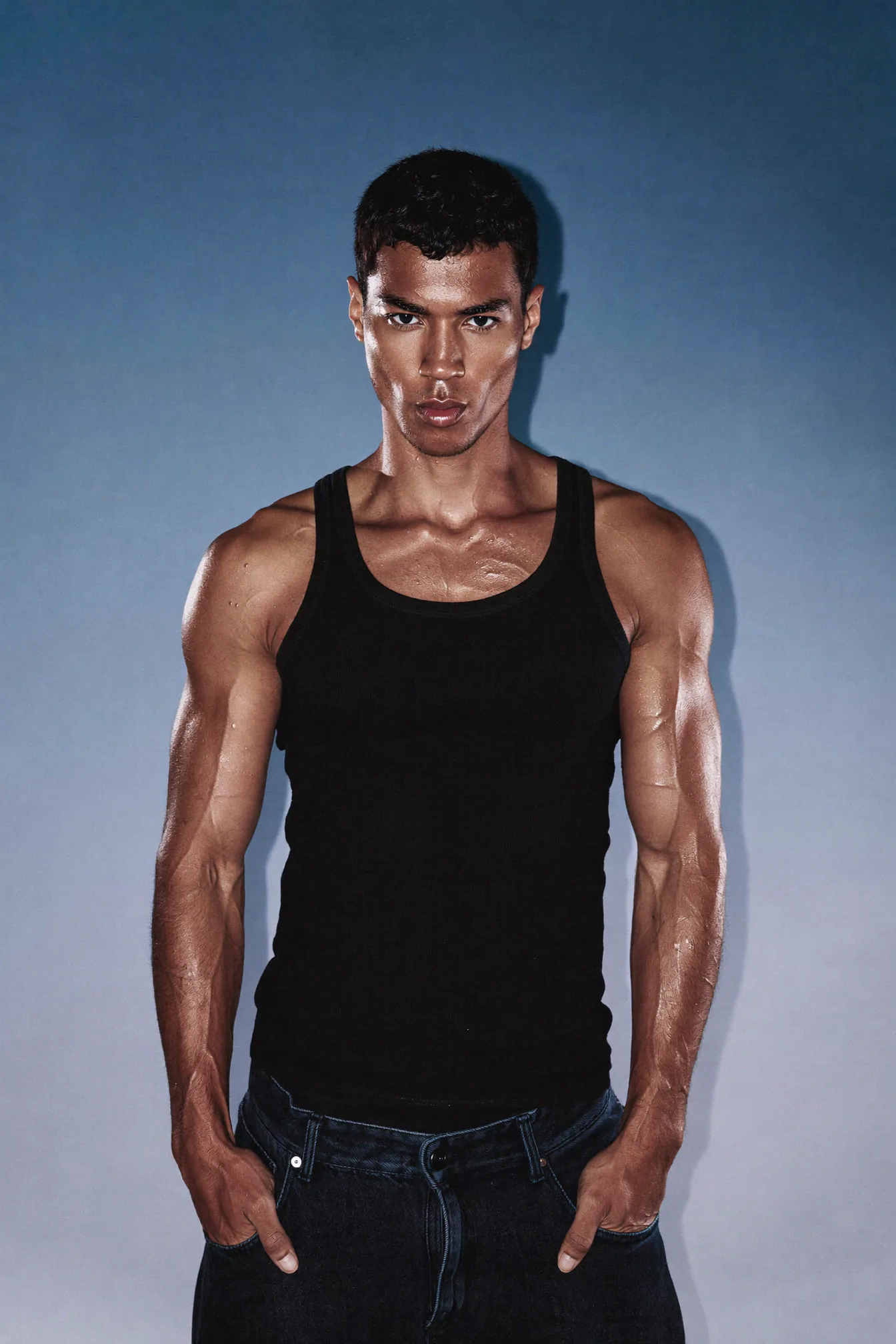 Athletic male model in a minimal blue studio portrait