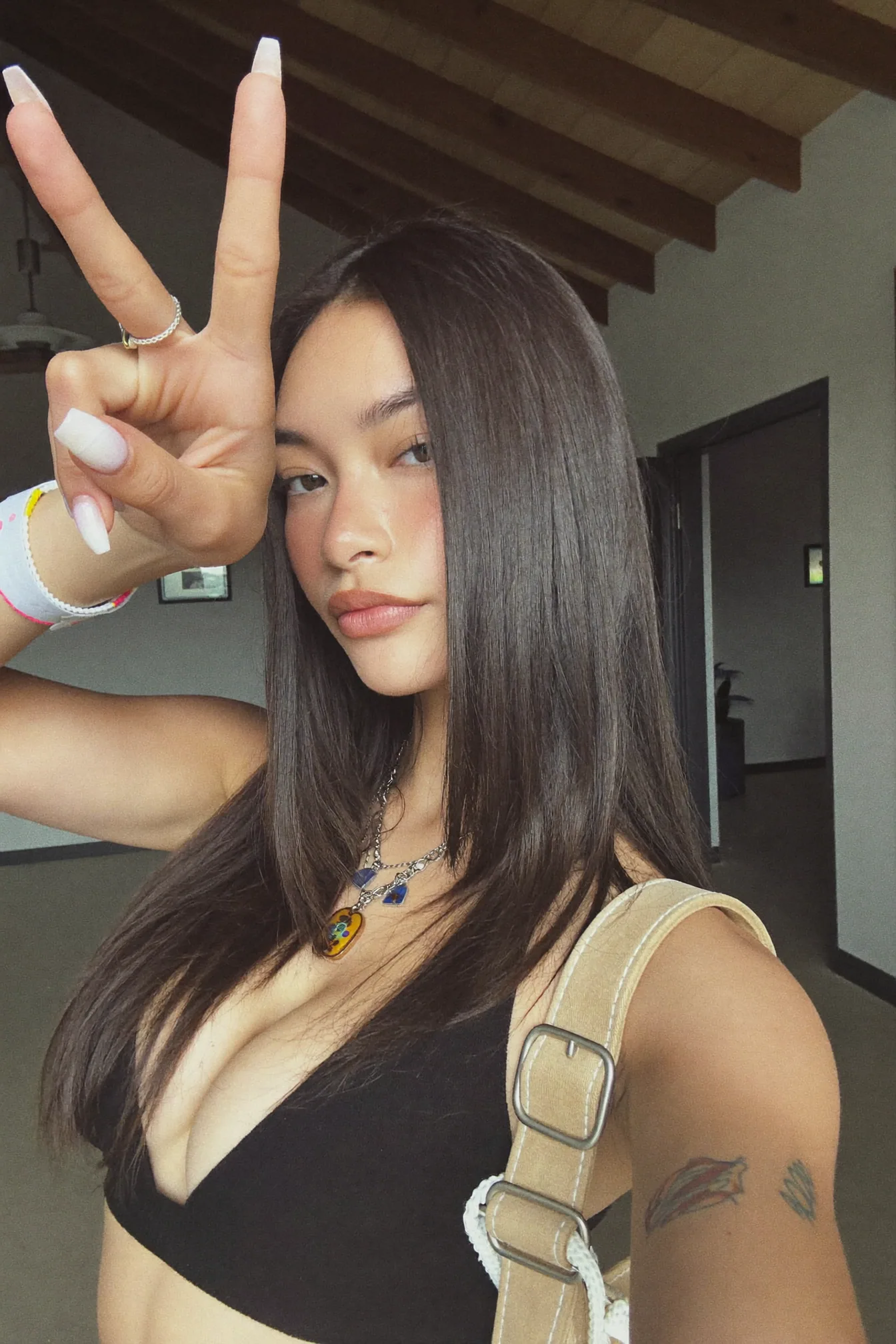 Casual indoor creator selfie with a peace sign
